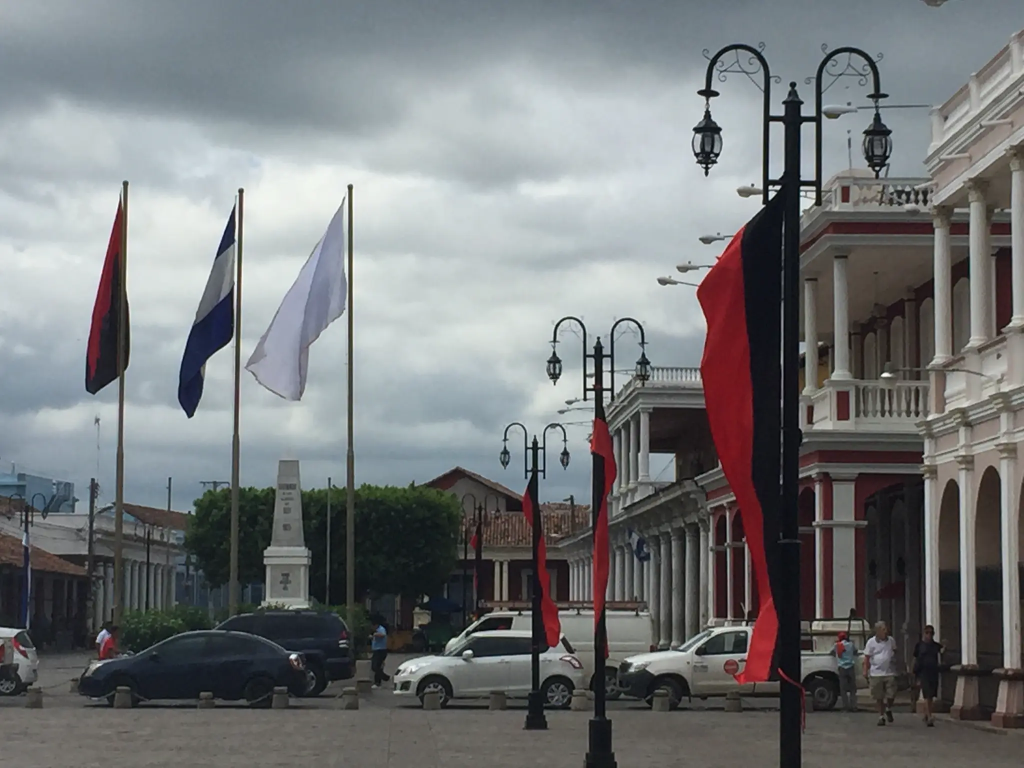 Granada central park Nicaragua with Nicaraguan flag and colonial arcade building