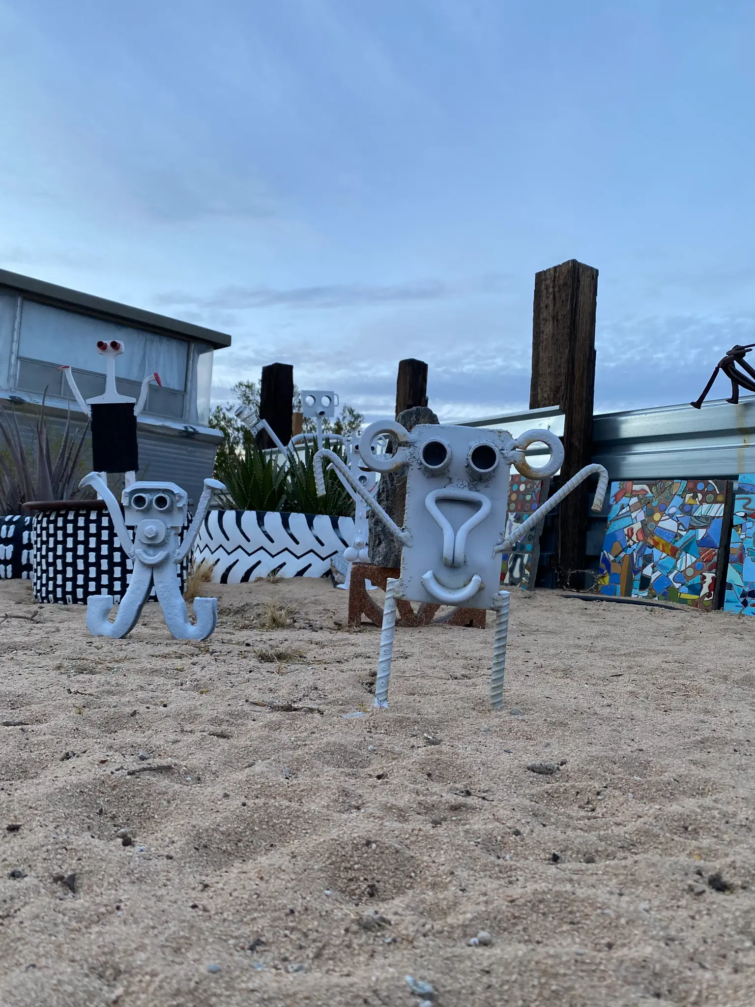 Whimsical metal sculptures in the sand at the Landers Airbnb property
