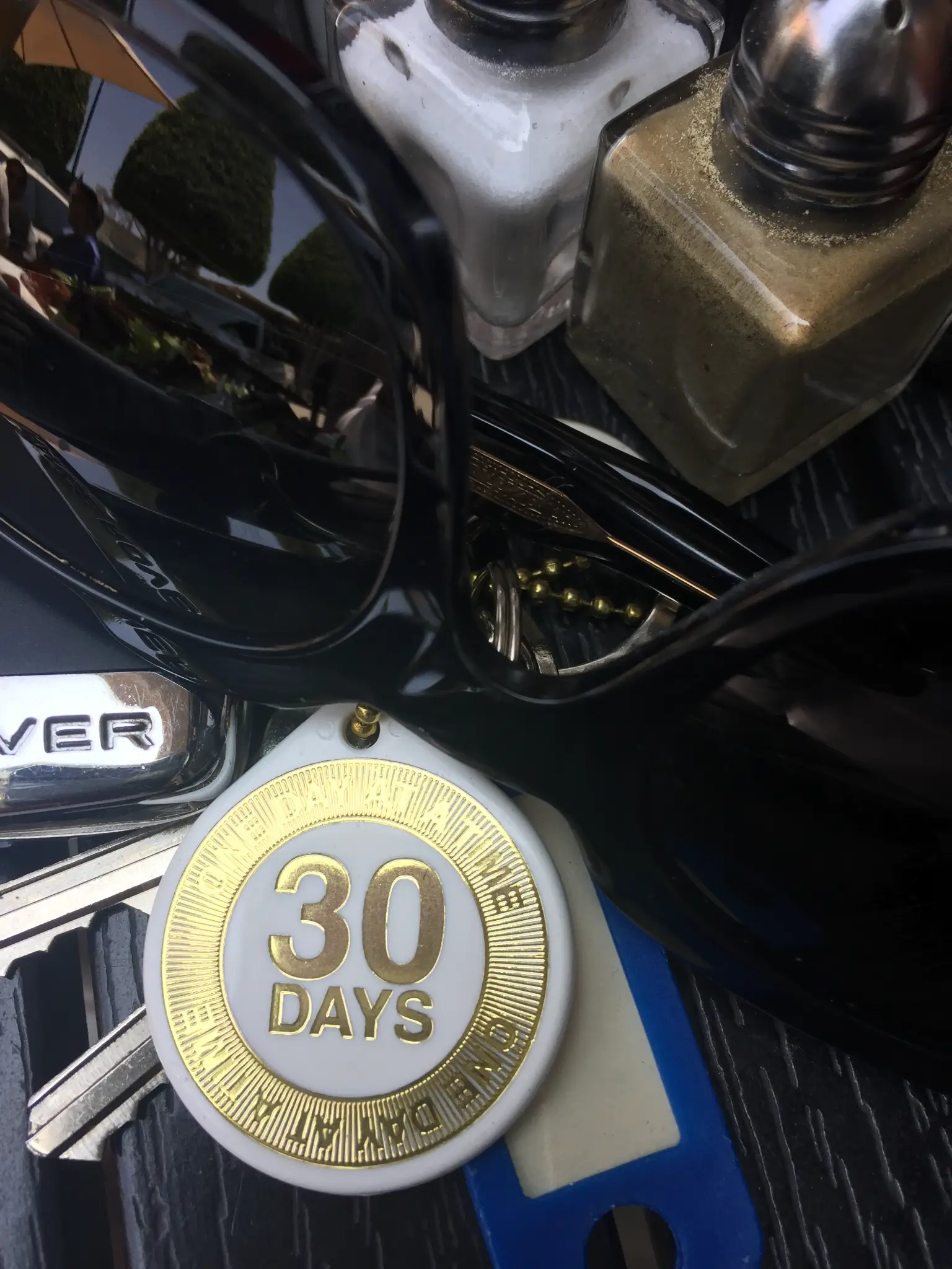 A 30 Days sobriety chip resting on a car dashboard