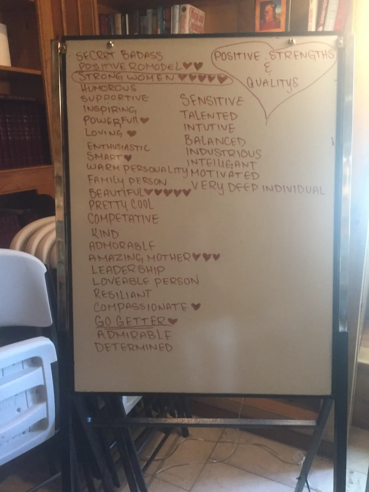 A whiteboard filled with positive qualities written by fellow patients in treatment: Secret Badass, Strong Woman, Beautiful, Amazing Mother, and more